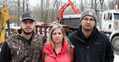 Sons Nick and Jonathon surround their mom Melissa Lepage as the family home is destroyed in the background.