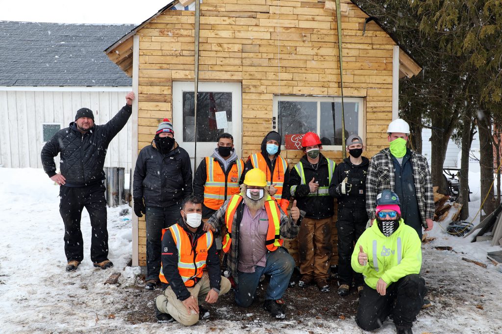 A group photo of the volunteers who moved the bunkie.