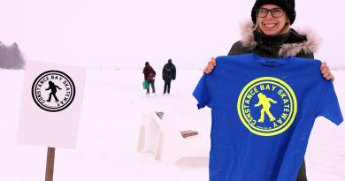 A photo of Jennie Joly holding a t-shirt with the Constance Bay Skateway logo on it.