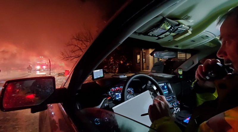 A firefighter works with dispatch from his car during last night's fire.