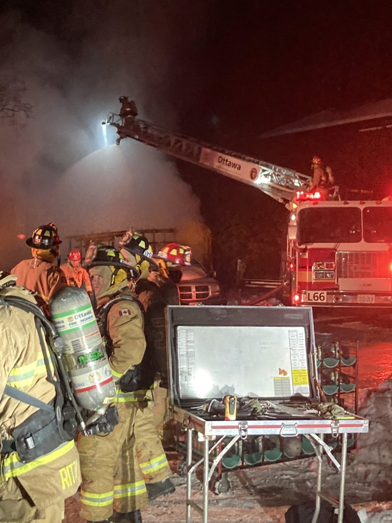 Firefighters in a ladder truck work the fire.