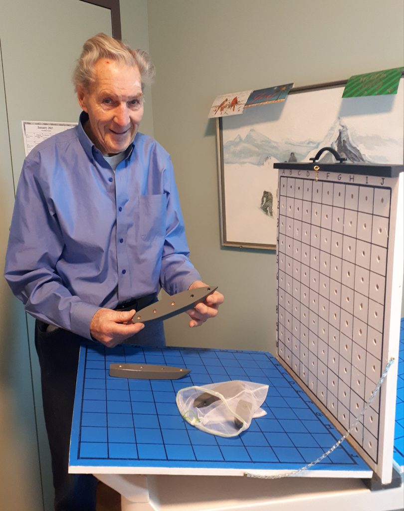 Fairview Manor resident Graham Burgess checks out the Battleship game, handmade by former neighbour Peter Baran. Courtesy Fairview Manor