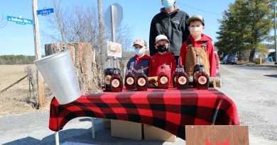 In front, from left, sixth-generation syrup makers Danny Badham, 6, Emmerson Graham, 6, and Lyal Badham, 7, with fifth-generation maker Austin Badham in back, pose at their Ferry Road stand last Saturday. Photo by Jake Davies