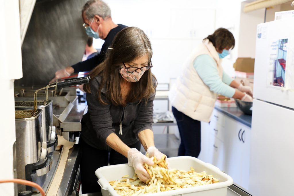 Legion volunteers work on creating fresh fish and chips for Good Friday's Meals to Wheels event. Photo by Jake Davies