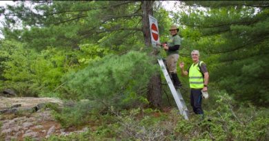 Volunteers install a sign along the trail.