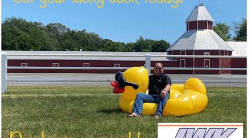Carp Fair President Neil Falls sits on a large rubber ducky.
