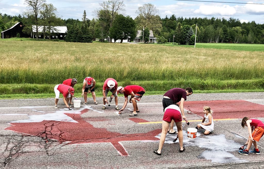 Volunteers paint a flag on Carp Road.