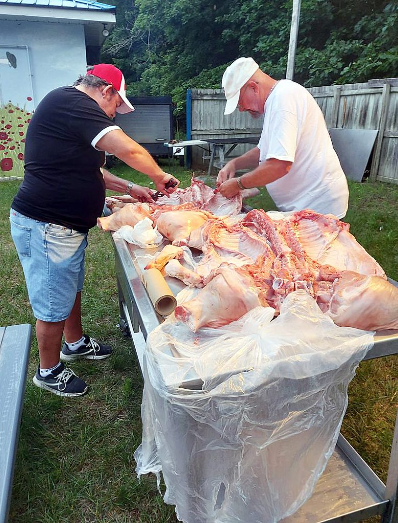 Rick Metcalfe and  Barry Milks prepare the pig for smoking.