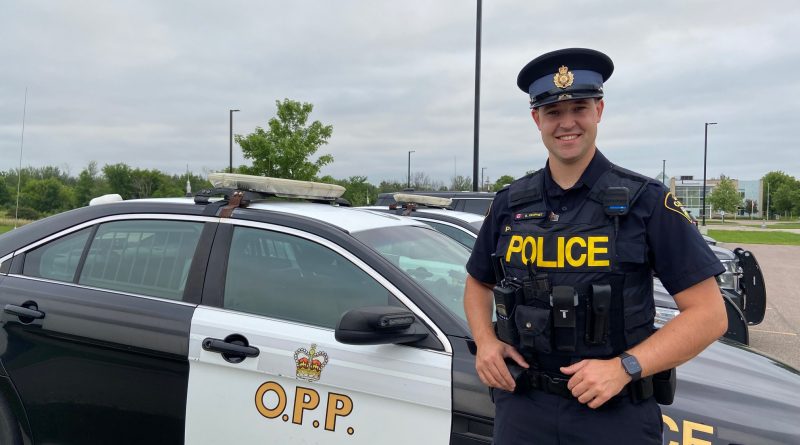 Const. Prohet poses in front of a cruiser.