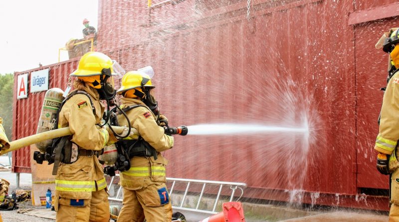 Two FFIT participants learn how to work a fire hose.