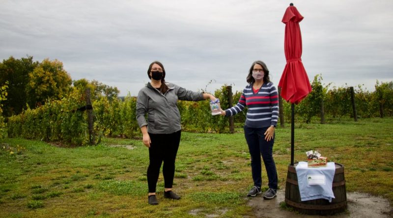 Alexandra Britton (left), Retail Manager and Sommelier at KIN Vineyards, draws the winners, with Josée Leblanc (right), Carp River Challenge organiser, at the beautiful vineyard location.
