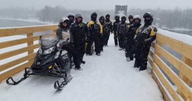 A photo of snowmobilers on the bridge.