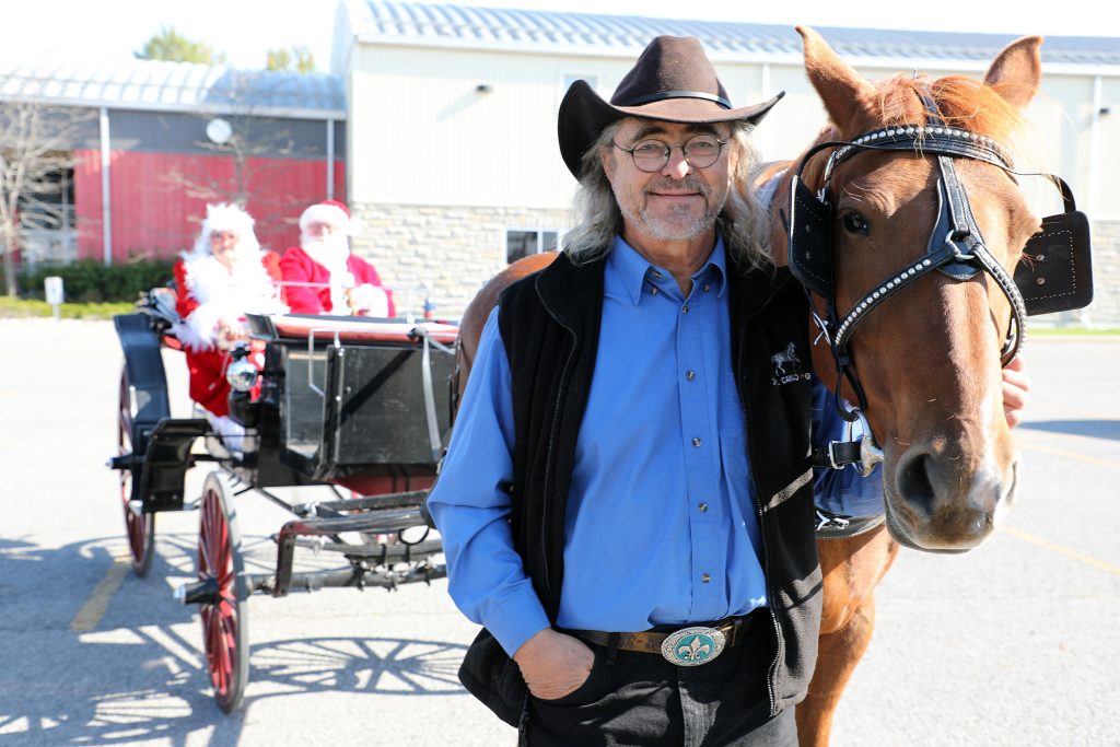 A photo of Michel and his horse and Santa and Mrs. Claus.