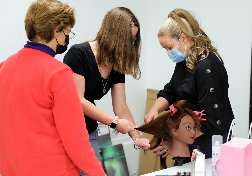 Julie Joinette shows Angela Knott how to braid.