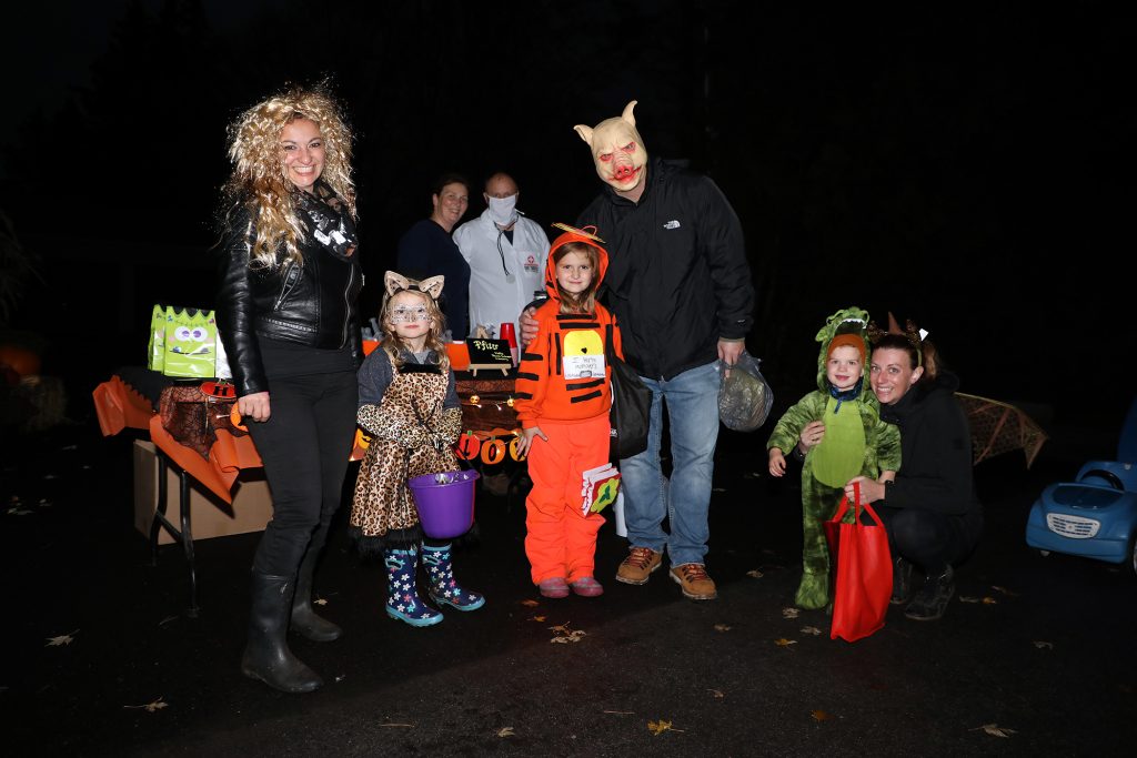 Trick-or-treaters pose for a photo in Marathon Village.