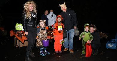 Trick-or-treaters pose for a photo in Marathon Village.