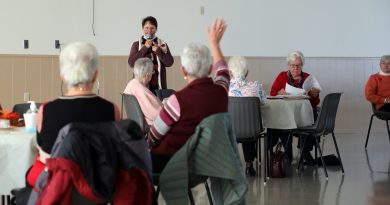 A photo of Judith Waddell speaking to seniors.