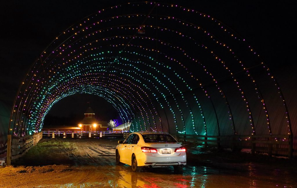 A car travels through  lit up dome.
