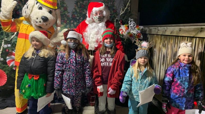 A photo of Sparky, Santa and the community choir.