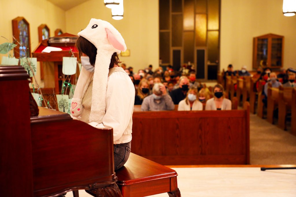 A young girl performs at the piano.