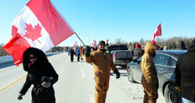 A photo of a man waving a flag on the March Road overpass.
