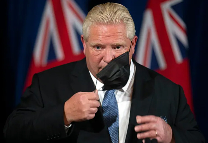 A photo of Premier Doug Ford taking off his mask.