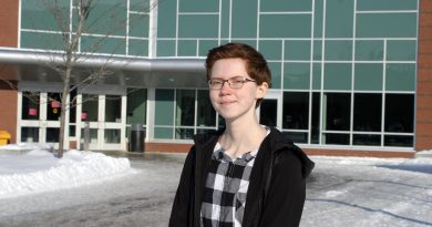A photo of Michelle Russett in front of the high school.