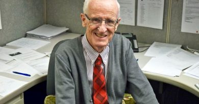 A photo of John Curry at his desk.