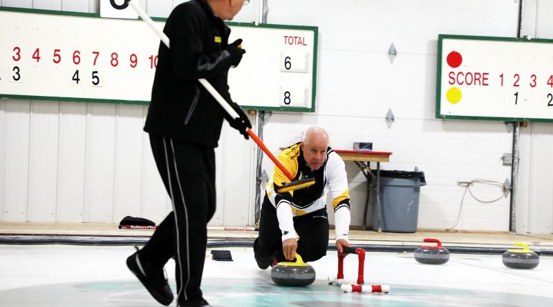 A photo of Blake Sinclair delivering a curling stone.