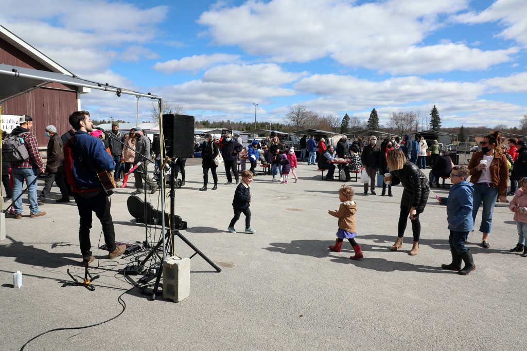 A photo of people enjoying music at the market.