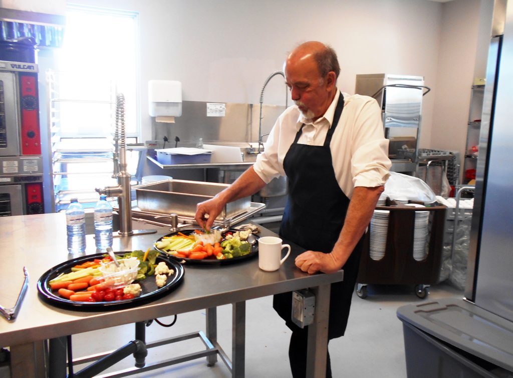 A photo of Len Russell working in the kitchen.