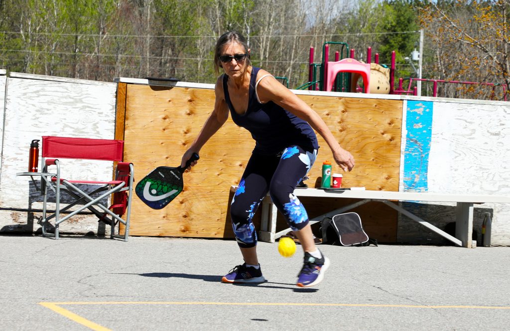 A photo of a woman playing pickleball