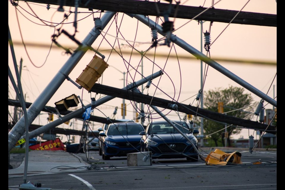 A photo of hydro lines down surrounding a car.