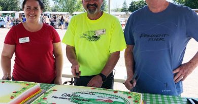 From left, Carp Farmers’ Market vice president Sarah Hunt, market manager Ennio Marcantonio, and President Randy Maguire pose for a photo before serving birthday cake. Courtesy the Carp Farmers’ Market