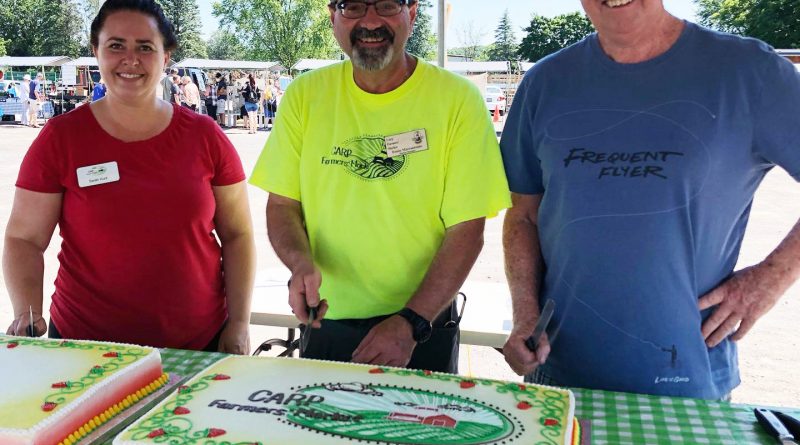 From left, Carp Farmers’ Market vice president Sarah Hunt, market manager Ennio Marcantonio, and President Randy Maguire pose for a photo before serving birthday cake. Courtesy the Carp Farmers’ Market