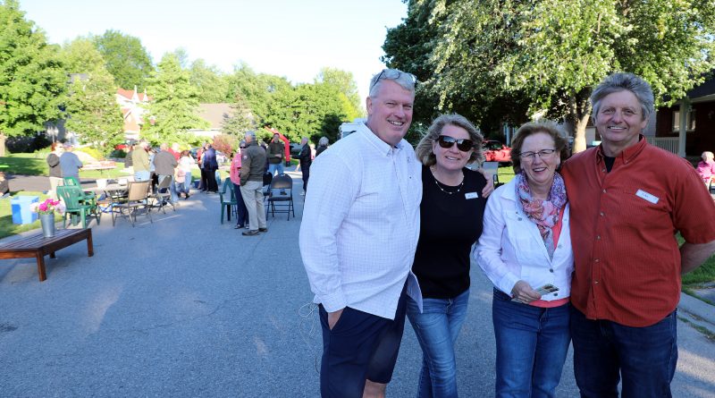 From left, Inniskillin Drive residents Peter and Alison Green, Jen Bonaparte and John Barber pose for a phot while the street party continues in the background. Photo by Jake Davies
