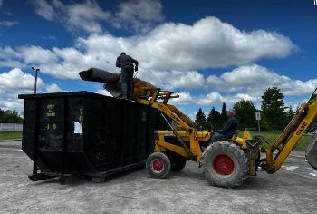 A photo of a tractor loading a bin.