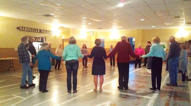 A photo of square dancers performing.