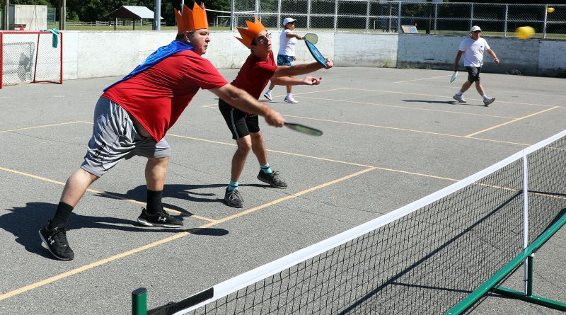 A photo of a father and son playing pickleball.