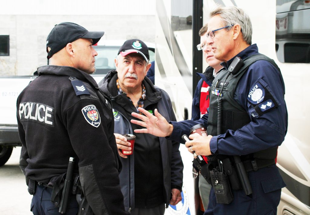 A photo of Eli speaking with police.