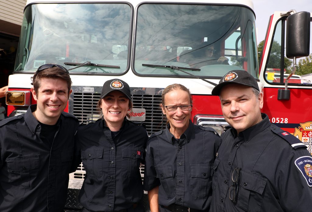 Four firfighter pose in front of a fire truck.