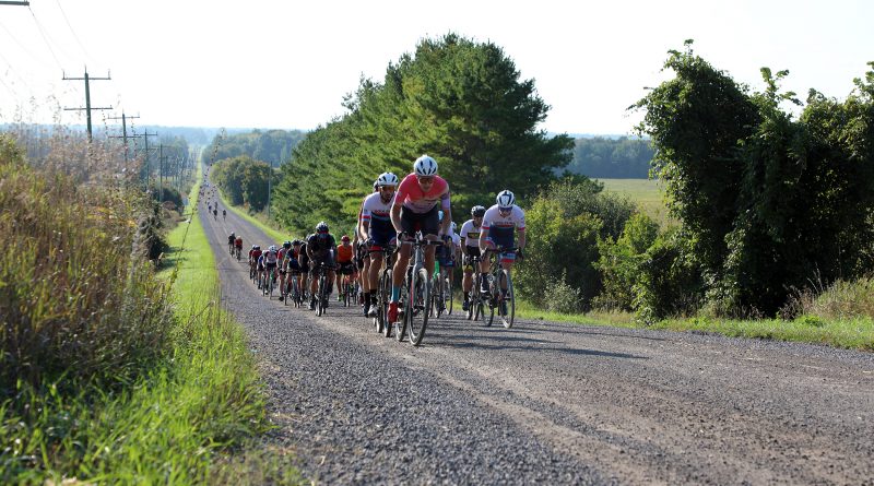 A photo of cyclists on a gravel road.