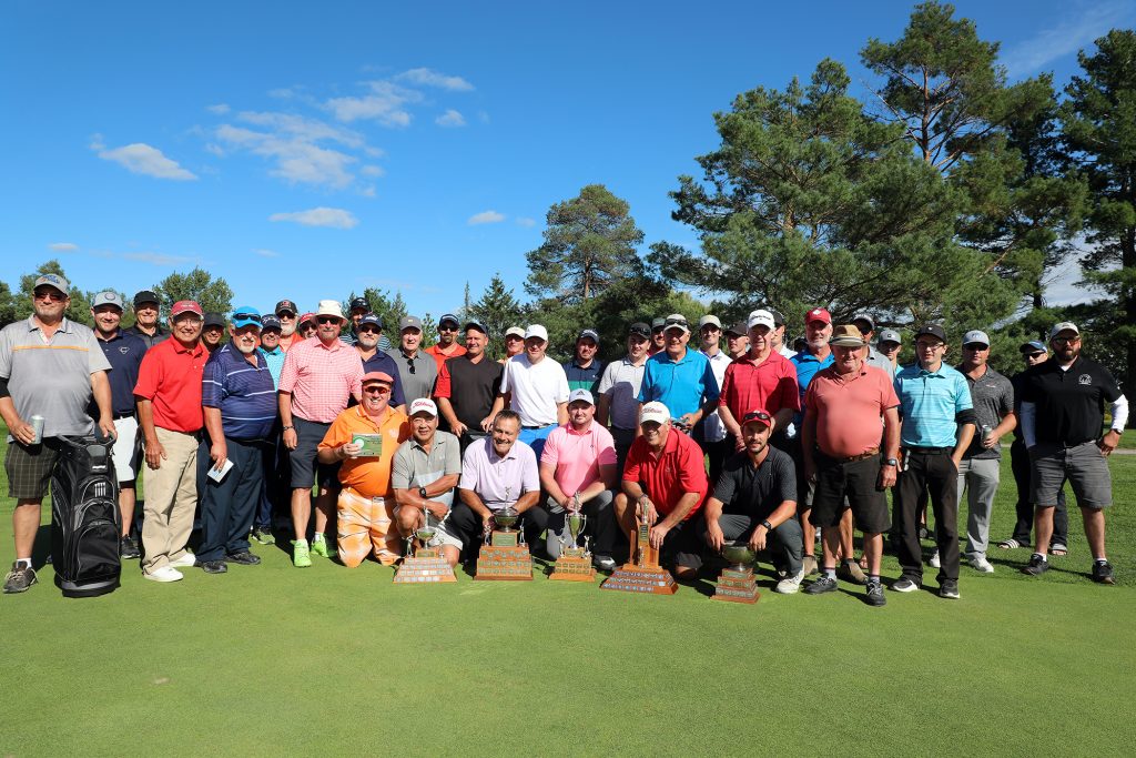 A group of men pose on the putting green.