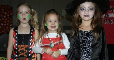A photo of three young childen in Hallowe'en costumes.