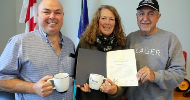 A photo of three people holding a letter of commendation.