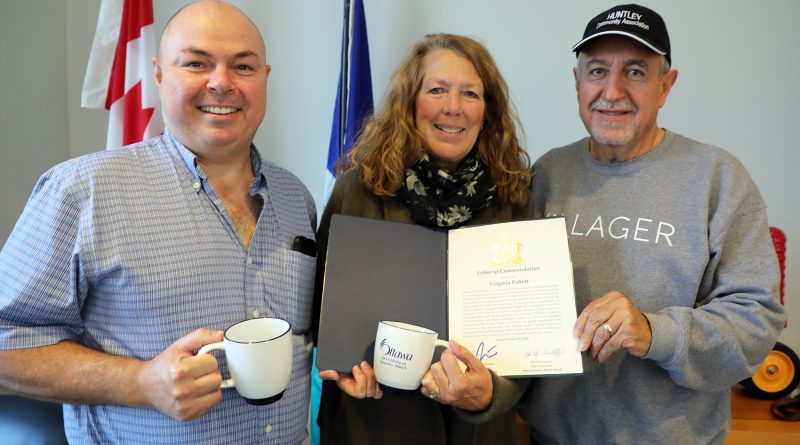 A photo of three people holding a letter of commendation.