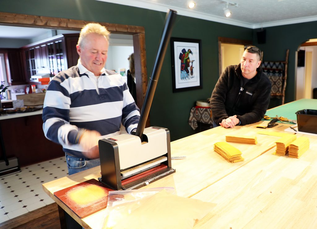 A man operates a leather press.