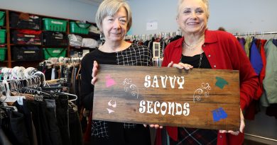 A photo of two women holding a sign that reads Savvy Seconds.