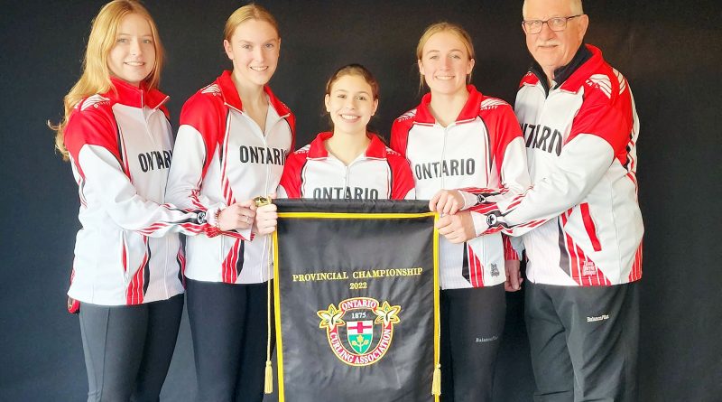 A photo of Team Frlan holding the provincial banner.