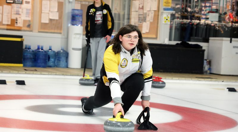 A curler hurls a rock down the ice.
